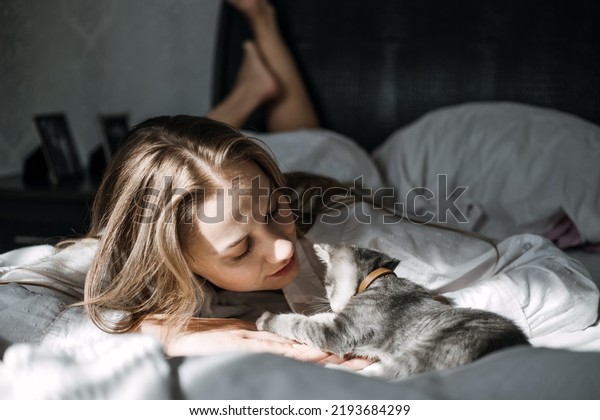 Mindfulness, Being in the\
present moment, here and now. Young woman play with kitten at home\
in morning