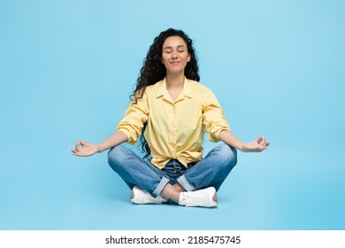 Mindfulness. Calm Arabic Woman Meditating Sitting In Lotus Position Doing Om Gesture Relaxing Over Blue Studio Background. Yoga Exercise And Meditation Concept - Shutterstock ID 2185475745
