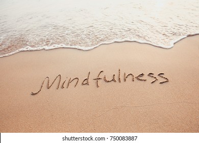 mindfulness concept, mindful living, text written on the sand of beach - Shutterstock ID 750083887