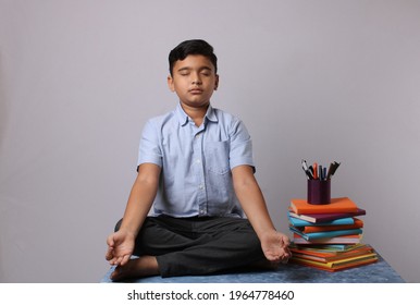 Mindfulness, Meditation And Relaxation Concept - Indian Boy With Headphones Listening To Relaxing Music And Meditating In Lotus Pose At Home. Eyes Closed 