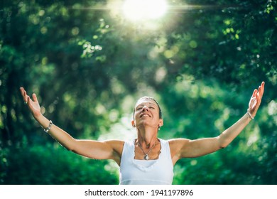 Mindfulness In Nature. A Positive Middle-aged Woman With Open Arms Connecting With Nature, Feeling