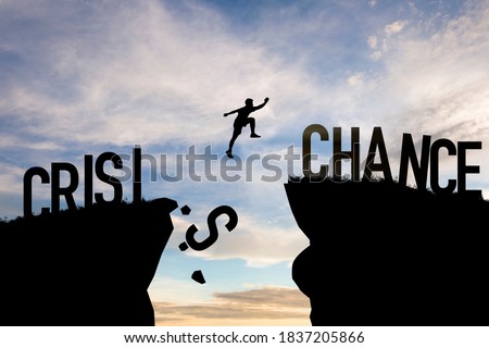 Mindset concept ,Silhouette man jumping from crisis to chance  wording on cliff with cloud sky.