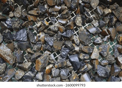 Mine, mining of tin (Sn) ore, as mineral cassiterite (SnO2). Background concept. Element used in Lithium-ion batteries, coils of superconducting magnets, pigments, solder, plating and bronze metal all