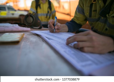 Miner Supervisor Inspecting And Checking JSA Risk Assessment Paper Work Permit Making Sure Safety Applying To The Right Job And Sign Its Off Prior To Work On Construction Mine Site, Perth, Australia