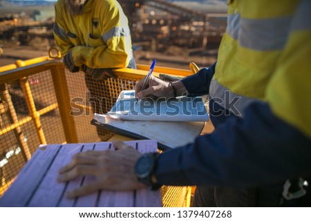 Miner supervisor review and sign of approval working at heights permit document prior to performing high risk work on construction plant mine site, Perth, Australia 