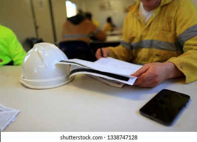 Miner worker supervisor double checking on safe risk assessment a job safety analysis (JSA) prior performing high risk task at construction mine site Perth, Australia    