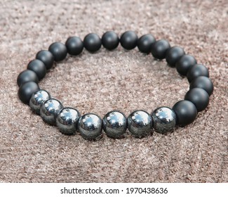 Mineral Bracelet, Bracelet Jewelry Made Of Different Types Of Round Gemstone Beads On A Wooden Background.  Onyx, Hematite