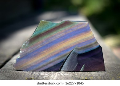 Mineral rainbow obsidian on a wooden background. - Shutterstock ID 1622771845