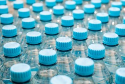 A view of three plastic water bottles without any labels, on a wooden ...