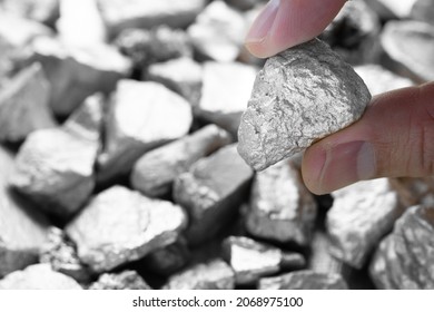 Miners hold in their hands platinum or silver or rare earth minerals found in the mine for inspection and consideration - Shutterstock ID 2068975100