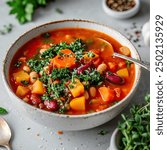 Minestrone soup in a bowl with vegetables and herbs, captured from an angle view, featuring a vibrant presentation, suitable for food photography.