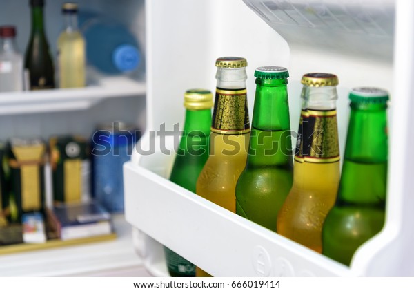 Mini bar full of bottles of juice and water\
in hotel room. The open door of mini fridge. Cold beer in home bar.\
Drink and food inside small\
refrigerator.