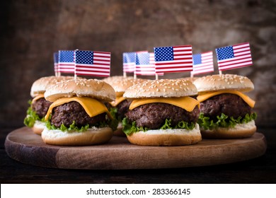 Mini beef burgers with American flag on wooden background,selective focus
