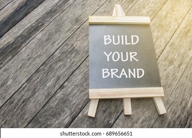 Mini Black Board Written Build Your Brand Concept Isolated On Wooden Background