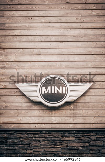 MINI Bull Bar Club, Pec pod Snezkou, Czech\
Republic  - July 23, 2016: Mini Cooper Car design logo on wooden\
and stone club wall in Krkonose mountains  - pastel and dark  brown\
vertical vintage design