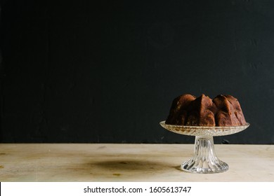 Mini bundt cake on a cake stand against a dark background with plenty of negative space to add a text. - Powered by Shutterstock