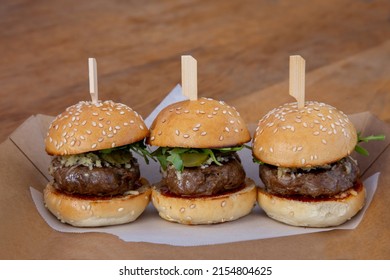 Mini Burger Sliders On A Wooden Board Up Close Low Light With Grain And Out Of Focus