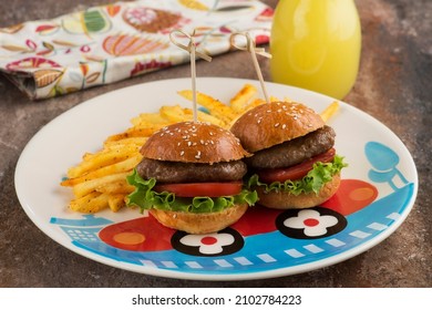 Mini burgers and fried potatoes on a children's plate with a lemonade. Kids meal. Kids Menu.