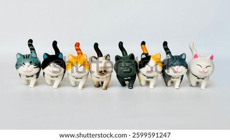 Mini cat doll made of plastic. With happy smiling face. Cute cats playing together. Free space for text.