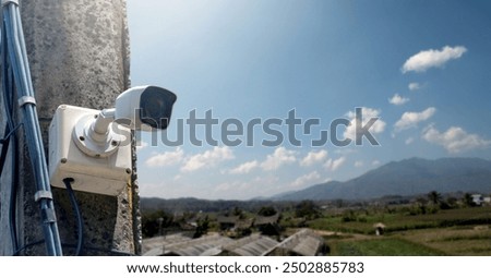 Mini CCTV camera is currently installed in the high cement pole beside the farmland to provide security through monitoring of farmowners via tablet, mobile phones and computers, soft focus.