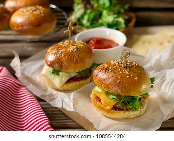 Mini Cheeseburgers Sliders With Ground Beef, Cheddar, Lettuce, Onions And Tomato Sauce