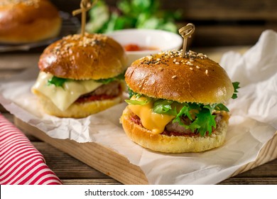 Mini Cheeseburgers Sliders With Ground Beef, Cheddar, Lettuce, Onions And Tomato Sauce