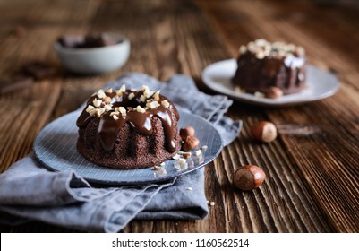 Mini Chocolate Bundt Cakes Topped With Glaze And Chopped Hazelnuts