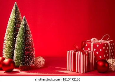 Mini Christmas tree and gift box on red background blank copy space for text. - Powered by Shutterstock