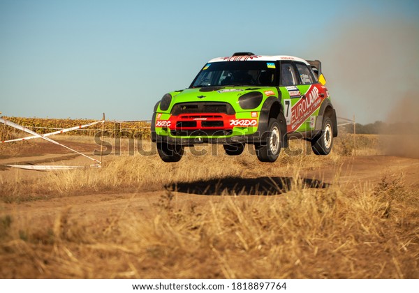 Mini Cooper rally car jumping in motion with\
clouds of dust during the Ukrainian Championship in mini-rally\
\