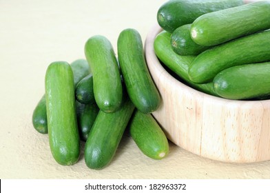 Mini Cucumbers In Wooden Bowl On Table 