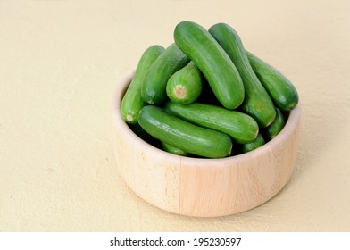 Mini Cucumbers In Wooden Bowl On Table