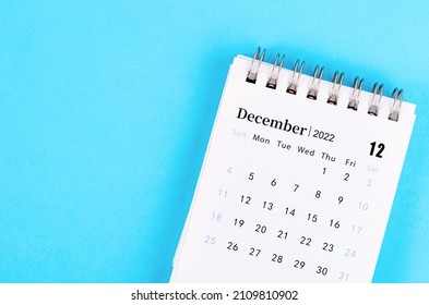 The mini December 2022 desk calendar on blue background. - Shutterstock ID 2109810902
