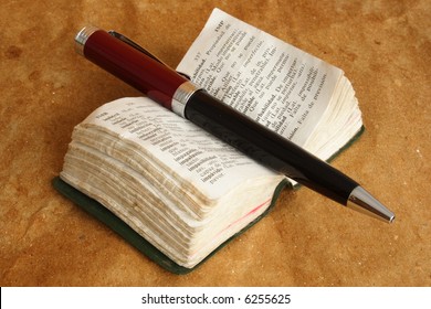 Mini dictionary opened with pen on top