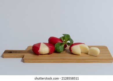 Mini Edam Ball Cheese Coated With Red Wax On A Wooden Board