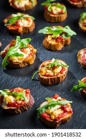 Mini Eggplant Appetizers With Tomato, Cheese And Salad On Black Background. Healthy Pizza Snack