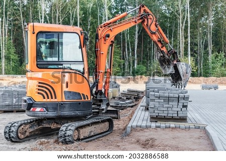 Mini excavator at the construction site. Compact construction equipment for earthworks