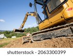 Mini excavator digging preparing ground under home garden