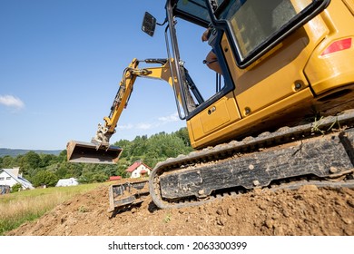 Mini excavator digging preparing ground under home garden