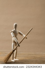 Mini figure of storm troopers cleaning the floor using a mop on a wooden background. Miniature robot on a wooden background. Mini troopers helping in household activities.