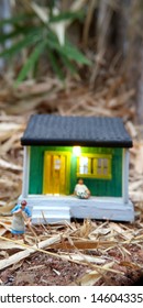 Mini Figure Toy Indonesian Woman Cleaning The Terrace And Old Man Using Sarung, Kopiah And White Shirt, Sit At His House, Beyond Bamboo Forest With Copy Or Negative Space For Text Placement Area