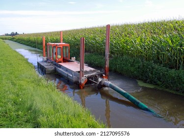 Mini Floating Suction Cutter Dredger In Operation   The Cutter Arm Cuts The Sediment And Pumps It Into A Pipeline (invisble)  Poles Keep It In Positio