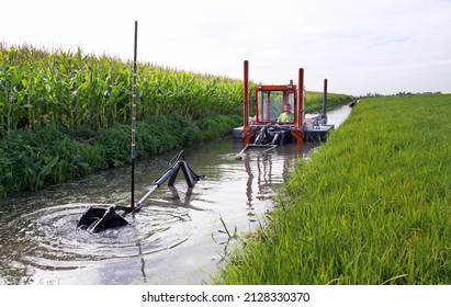 Mini Floating Suction Cutter Dredger In Operation   The Cutter Arm Cuts The Sediment And Pumps It Into A Pipeline (invisble)  Poles Keep It In Positio