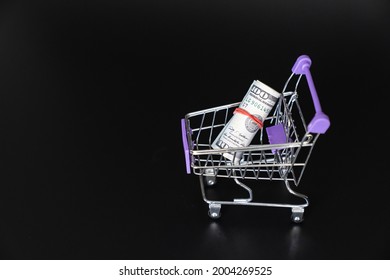 Mini Food Basket With 100 Dollars On A Black Background. Investing And Storing Money. The Concept Of Frugality And Financial Literacy.