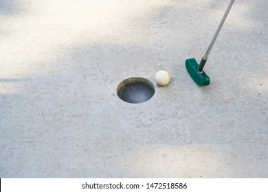 Mini Golf Club Hits The Ball Into The Hole On A Track From Concrete, Copy Space, Selected Focus