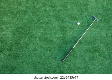 Mini golf equipment, golf club and ball on green ground  - Powered by Shutterstock