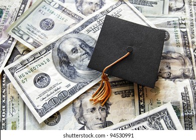 Mini Graduation Cap On Top Of A Pile Of Cash