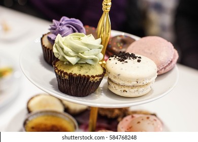 Mini Green Tea Cupcakes And Oreo Macaroons On A Dessert Stand With Afternoon High Tea