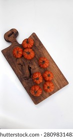 Mini Heirloom Tomatoes on Rustic Wooden Cutting Board. Fresh organic heirloom mini tomatoes arranged on a rustic wooden cutting board over a clean white background. Top view with copy space, ideal for healthy food, farm-to-table, agriculture, cooking ingredients, and fresh produce concepts.