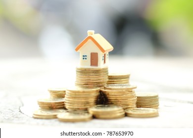 Mini house on stack of coins. Concept of Investment property loan.