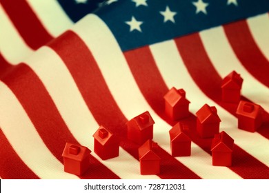 Mini houses against USA flag background. Citizenship, residence, property, real estate concept.